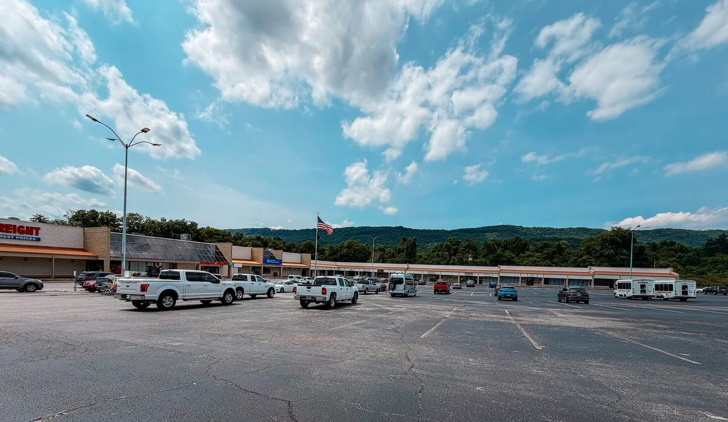 The shopping plaza parking lot with the East Tennessee hills behind