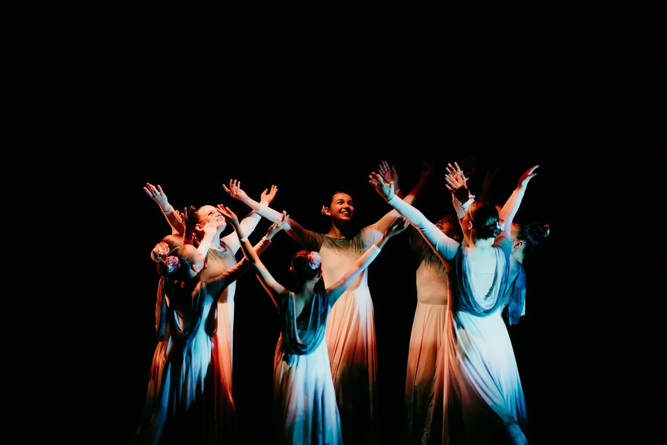 Sanctuary dancers worshiping on stage, arms lifted